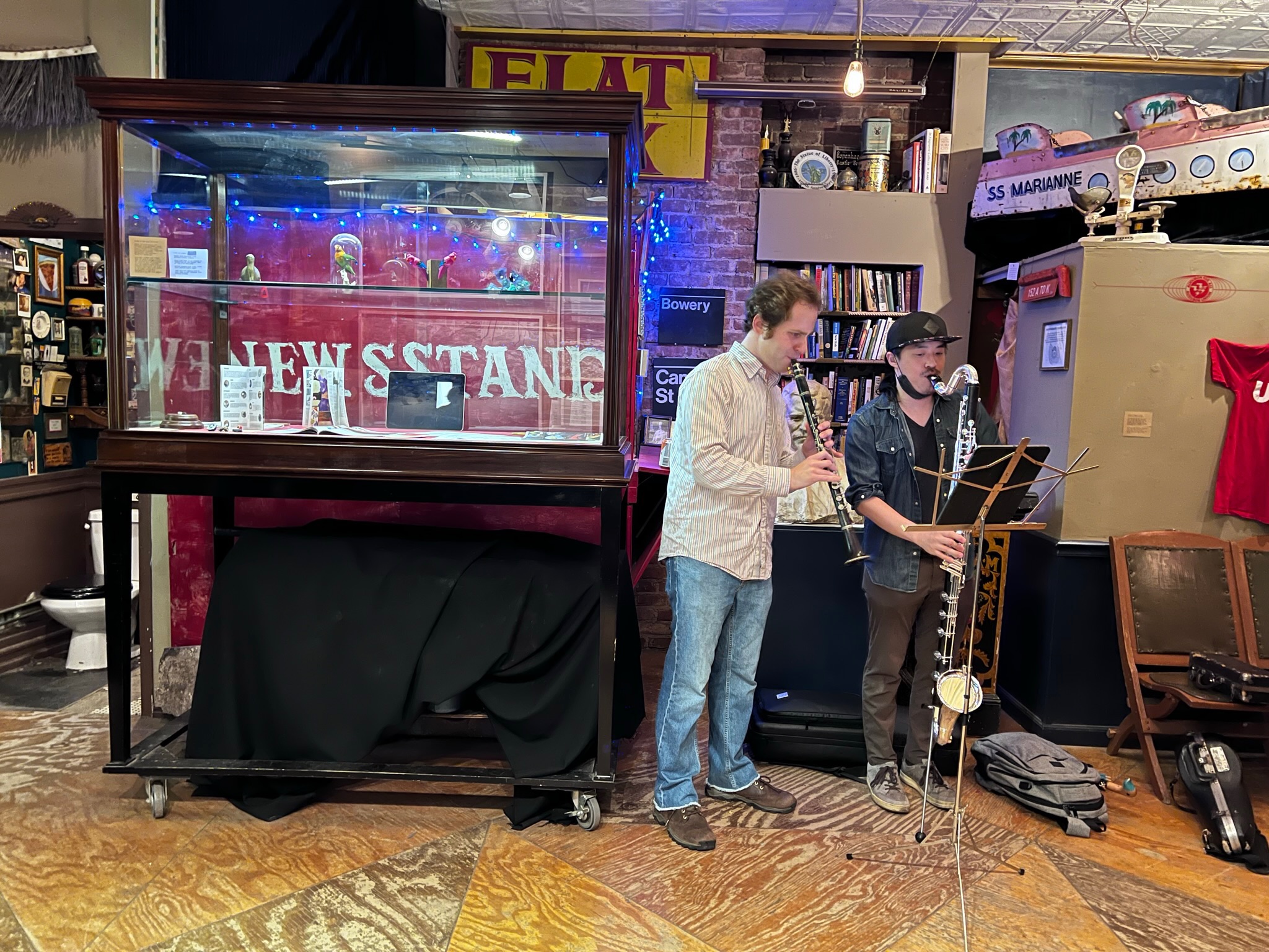 two musicians stand playing oboe and saxophone