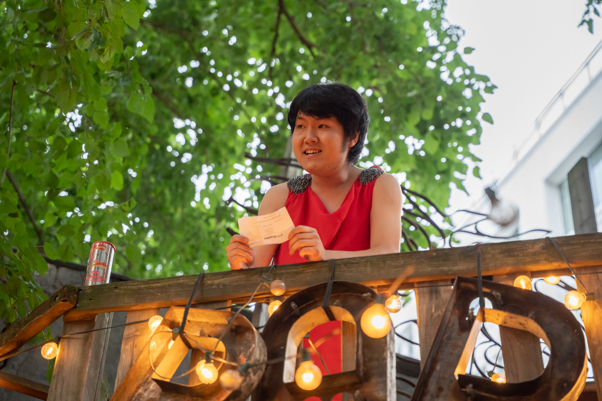 a performer reads a card casually from atop the bar