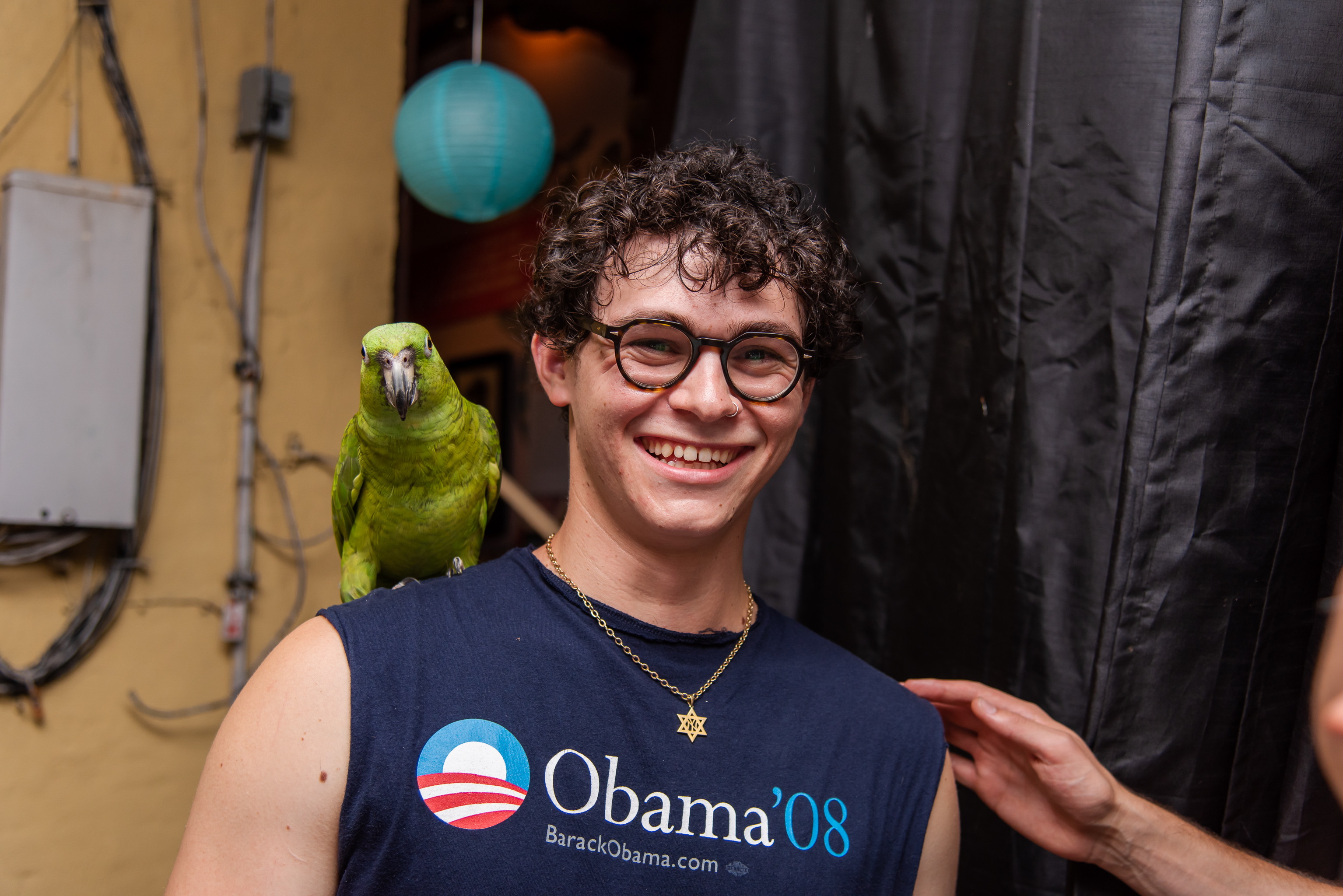 Charlie of Petting Zoo smiles with a parrot on his shoulder